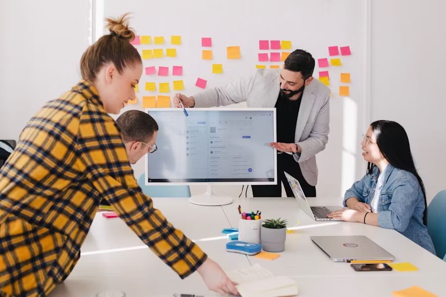 Diverse team collaborating in a modern office using cutting-edge technology on a computer monitor for a presentation.
