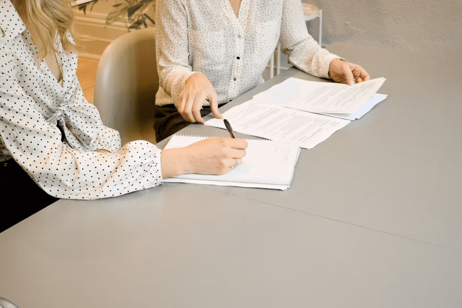 Professionals review SEC reporting requirements documents and take notes at a table.