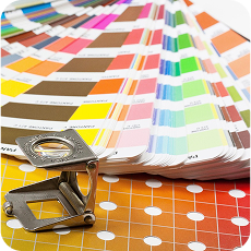 Linen tester loupe beside a color swatch fan on a printed sheet, showcasing professional color enhancement tools.