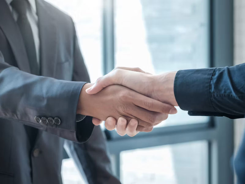 A business handshake symbolizing a deal, potentially related to a transaction with an SEC Filing Fee.