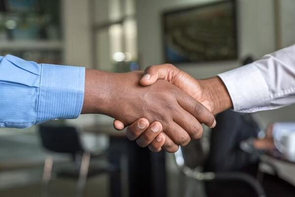 Professionals shaking hands in an office after successfully managing complex EDGAR filing deadlines.