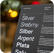 Multilingual silver typography on dark paper highlighting professional financial printing services with bokeh lights