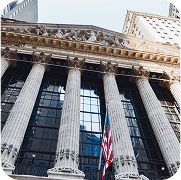 Grand classical building exterior with large columns and an American flag, representing a U.S. stock exchange