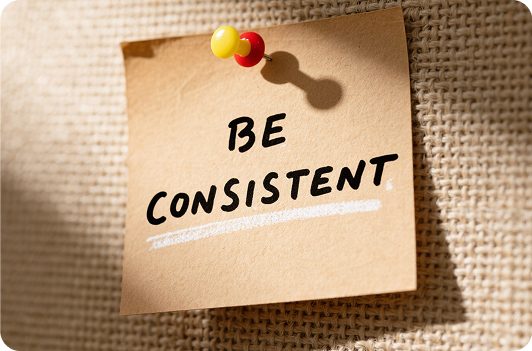 Brown sticky note reading BE CONSISTENT pinned to burlap, serving as a visual cue for Design Consistency. Brown sticky note reading BE CONSISTENT pinned to burlap, serving as a visual cue for Design Consistency.